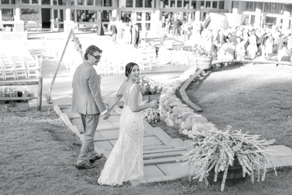 Bride and groom at Sugarloaf USA Black and white portrait of bride and groom holding hands and walking down a stone path at Sugarloaf USA