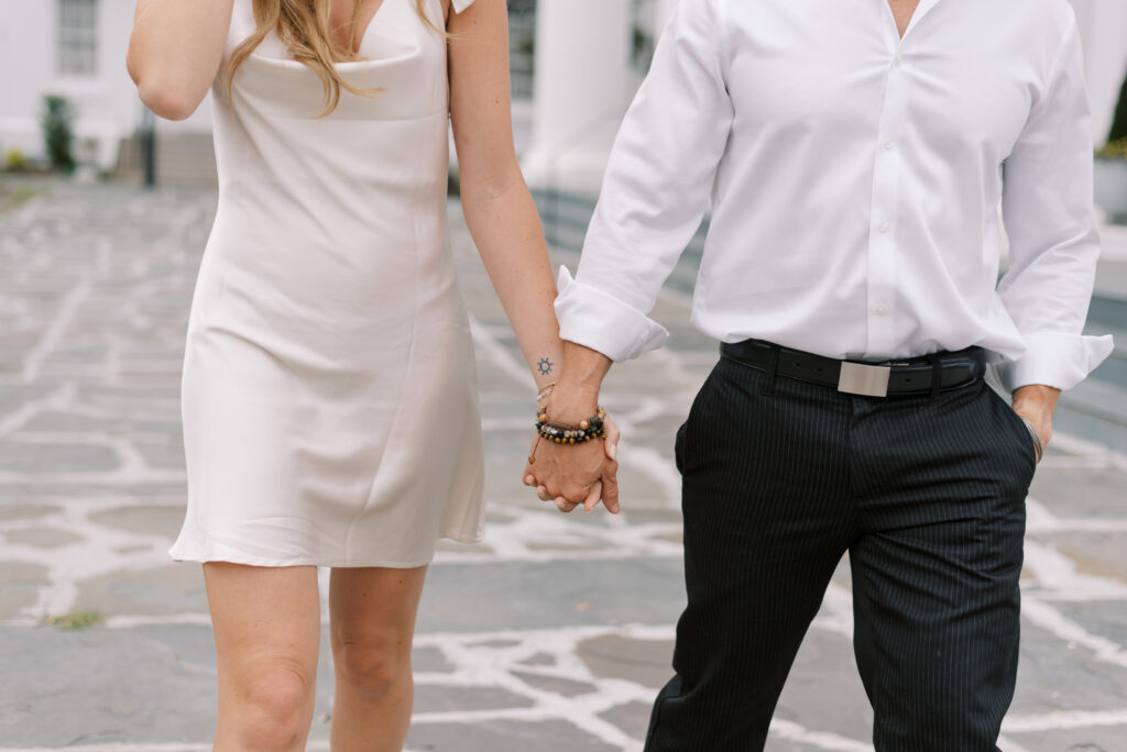 close up of engaged couple holding hands while walking