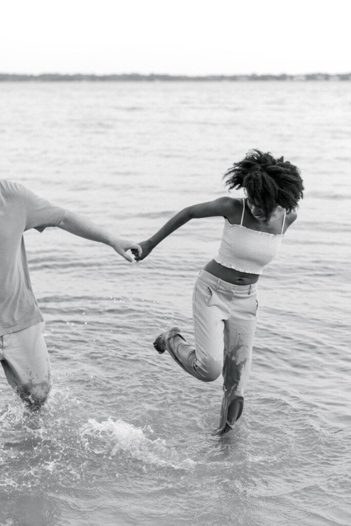 woman kicks water at her boyfriend