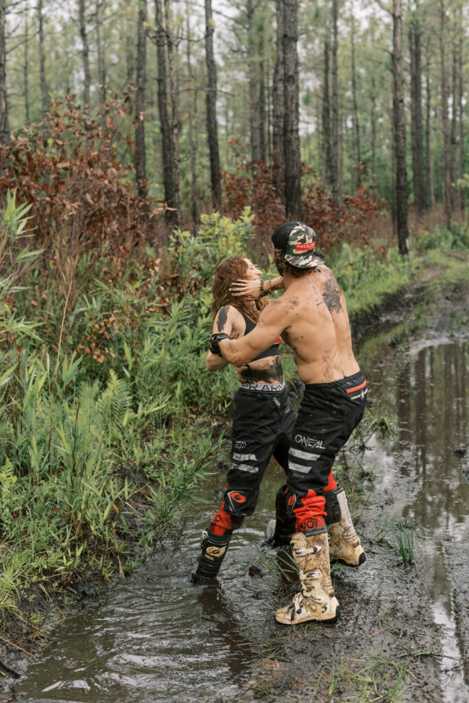 Couple mud wrestles in the middle of the south carolina woods during a dirt bike photo shoot